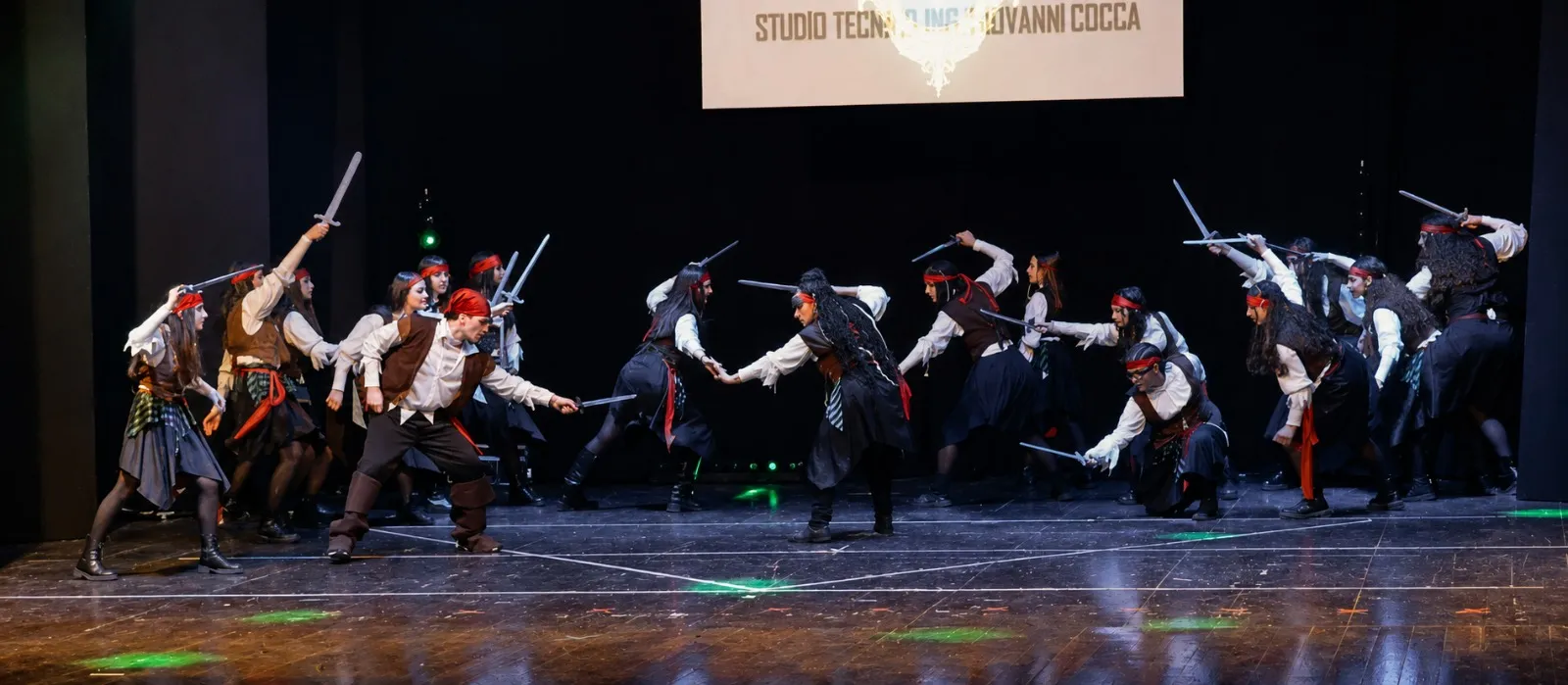 Gli allievi di Anima Danzante in costume da pirata, spade in pugno, si fronteggiano in due schieramenti sul palco durante uno spettacolo